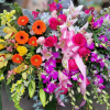 The elegant arrangement includes hot pint dendrobium, yellow cymbidiums, hot pink roses