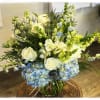 This arrangement contains blue hydrangeas, white roses and so much more.