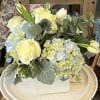 This arrangement includes blue hydrangea, white roses and tulips.
