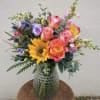 This multicolored arrangement has sunflowers, roses, lizzy and snapdragon.