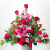 Rustic red container displaying a mix of high quality long stem roses