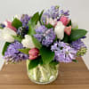 A simple elegant flower arrangement of fragrant hyacinths and tulips, with greenery