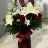 Arrangement of red roses white lilies mixed with other blooms in same