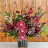 Unique and dramatic arrangement features richly colored maroon blooms! 
