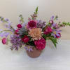 A sprawling garden-style arrangement featuring pink, purple, and lavender spring flowers.


The blooms