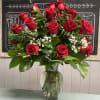 One dozen red roses, baby&#039;s breath and greenery in a vase