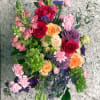 A charming mixed arrangement that showcases vibrant colors. Featuring roses, carnations, garden