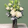 A serene mixed arrangement that showcases a white and green palette, featuring