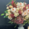 This stunning arrangement showcases peach garden roses, lush hydrangeas, and delicate spray