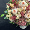 This stunning arrangement showcases peach garden roses, lush hydrangeas, and delicate spray
