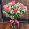 One dozen long stem roses arranged in an hourglass vase.