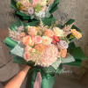 The bouquet features  a soft, romantic color palette, wrapped in rich
