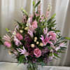 This pink floral arrangement contains a mixture of lilies, roses, wax, spray