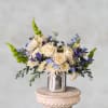 Calming blues, whites and greens are artfully arranged in a glass vase