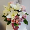 Crystal pink, frosted vase with white lilies, pink roses, and purple/white alstroemeria.