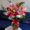 Crystal vase with an elegant arrangement of red &amp; pink roses, stems