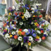 A bright colorful cremation wreath. Iris, daffodils, tulips, daisies, and a mix