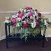 A full casket spray in shades of pink;  peonies, roses, carnations