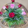 Dozen mixed rones in pink and red. Arranged in vase with greens