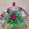 Dozen mixed rones in pink and red. Arranged in vase with greens