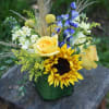 This cheerful arrangement filled with yellows and a touch of blue helps