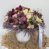 A stunning vase arrangement featuring calla lilies, orchids, roses, and wax flowers