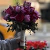 This elegant and romantic hand-tied bouquet is a rich composition of deep