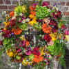 Classic large memorial wreath designed with multi-colored flowers and accented with ferns