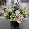 Pearly white lilies surrounded by creme white roses, white daisies, purple statice