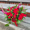 An all red arrangement using roses, carnations, stock and greenery in a