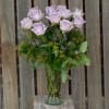 One dozen lavender roses arranged beautifully in lush greens.