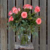 Beautiful coral roses expertly designed in a glass vase!