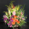 A garden of beautiful flowers, expertly arranged in a lovely ceramic dish.
