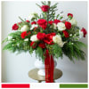 Lush evergreens, premium red and white roses, carnations, and berries combine in