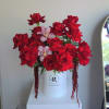 This luxurious floral arrangement features a stunning display of deep red roses