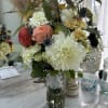 A beautiful vase with large and small dahlias, thistle, greens and other