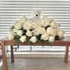 This floral arrangement features a soft and serene display of white roses