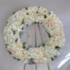 This classic funeral wreath is designed with ivory and champagne roses, white