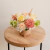 This flower arrangement showcases a soft and warm palette of ivory and