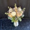 A mix of white and peach blooms arranged in a vase.