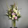 A dramatic garden style vase arrangement with roses, peonies and accompanying blooms
