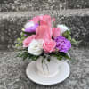 This arrangement has roses, spray roses , limonium , lisianthus, queens Ann
