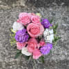 This arrangement has roses, spray roses , limonium , lisianthus, queens Ann