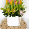 A cheerful design featuring yellow and pink tulips with green cymbidium orchids