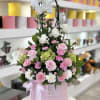 A graceful and romantic arrangement featuring white orchids, blush pink roses, carnations
