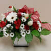 fresh spring arrangement filled with white and red flowers and ladybugs throughout
