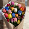 24 beautiful assorted colored roses wrapped in brown parchment paper.