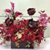 This dramatic arrangement is bursting with red and burgundy tones&mdash;featuring roses, anemones