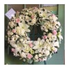 A beautiful european-style sympathy wreath in delicate whites and a touch of