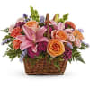 Like an island sunrise, this basket of orange and pink blooms are